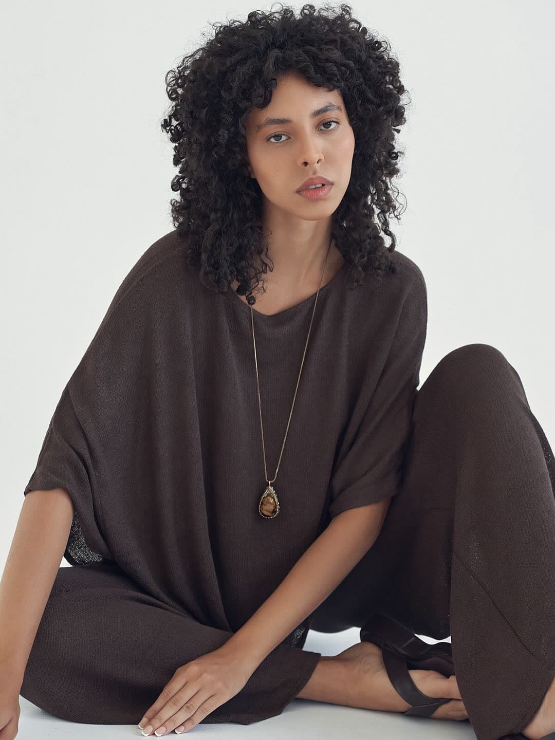 Test frame: Jess seated on the floor in a mocha knit set, knees drawn up