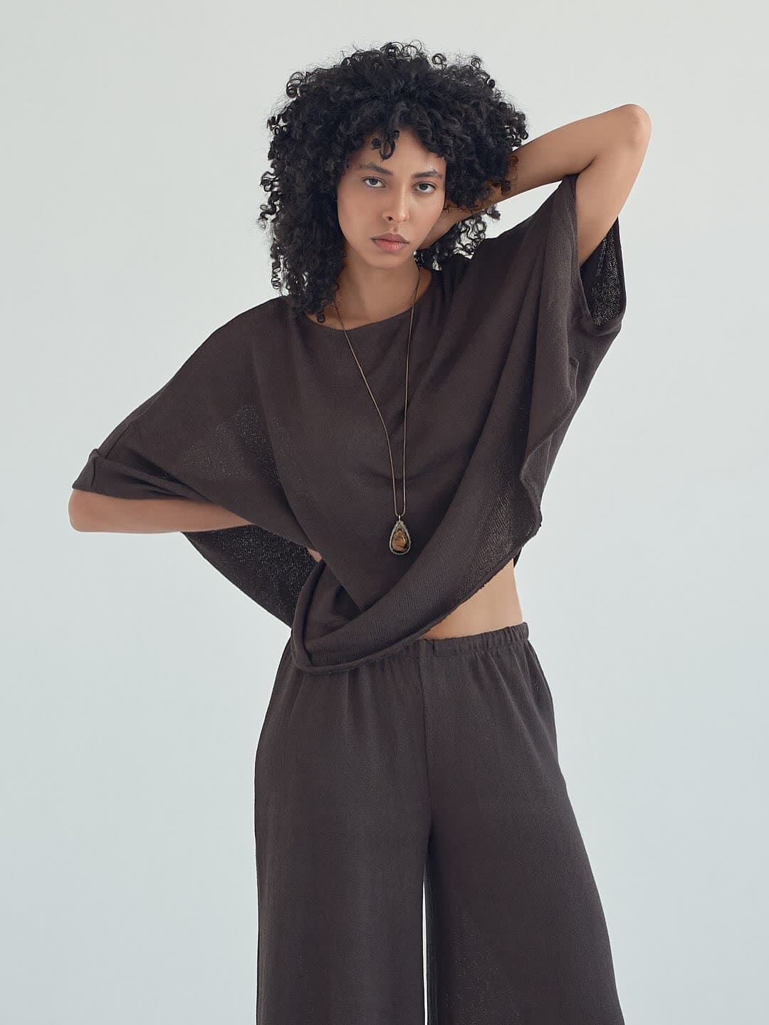 Test frame: Jess with a hand behind her head in the mocha knit set